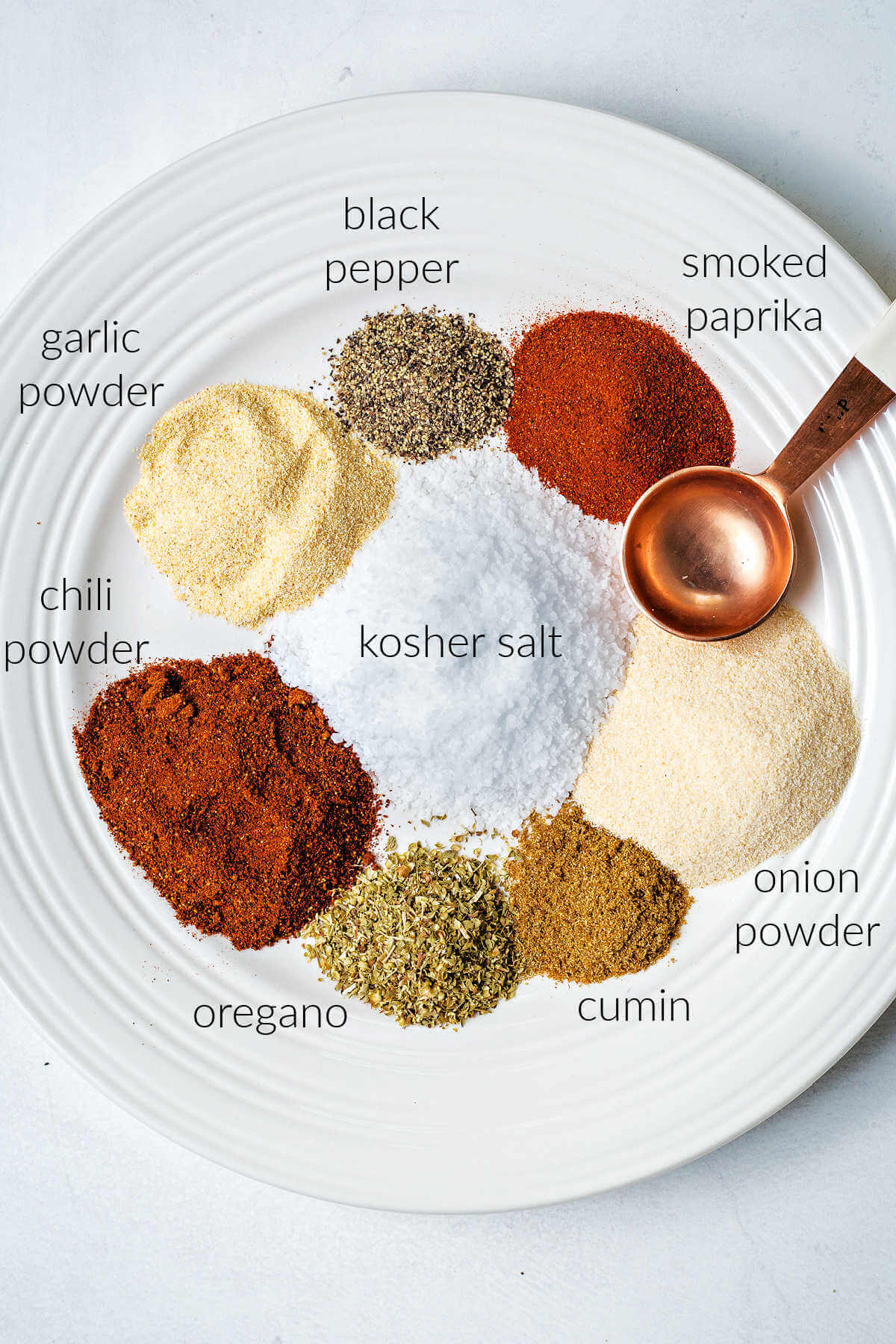 ingredients for homemade steak seasoning on a plate on a table.