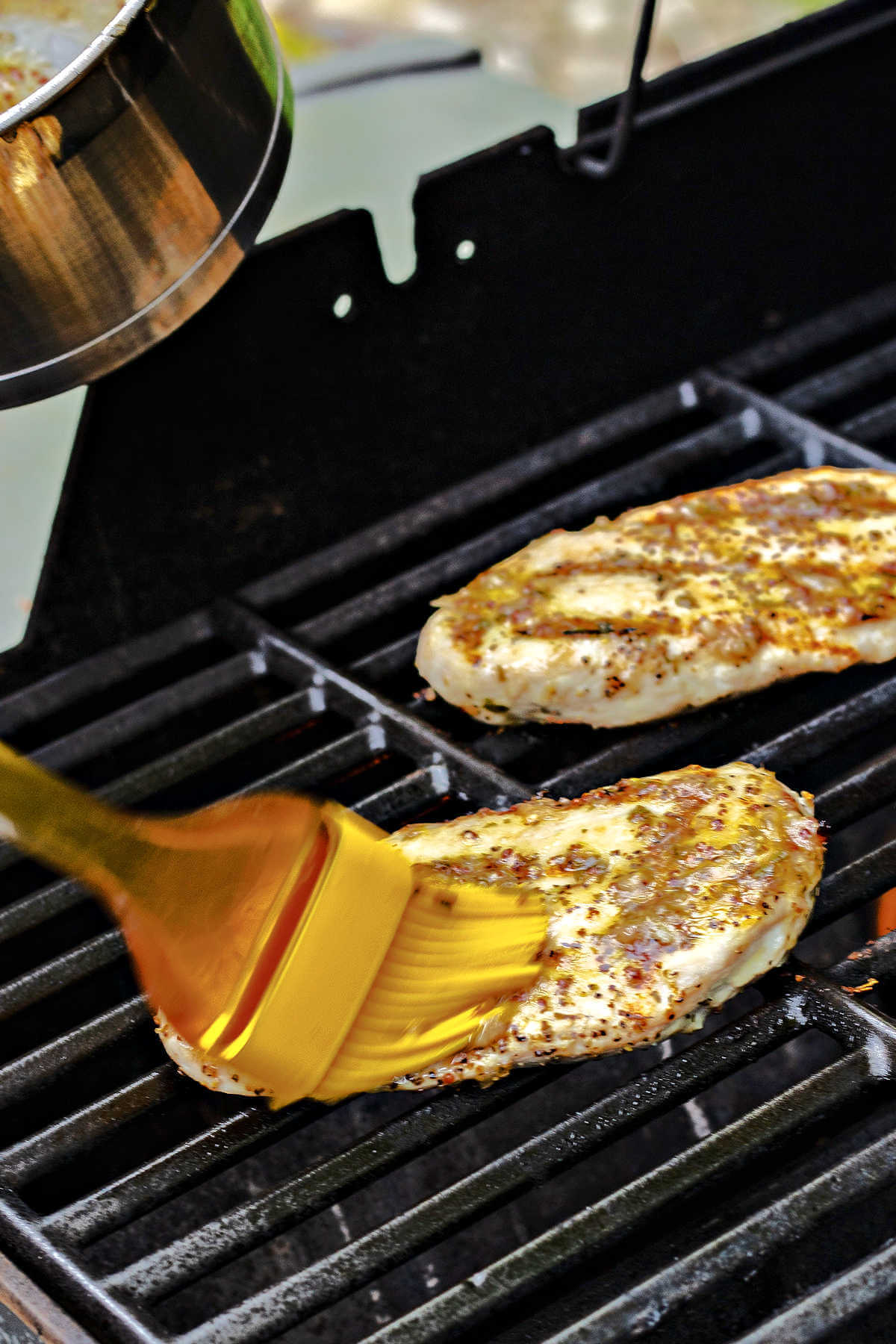 basting chicken on a grill with Carrabba's grill baste sauce.