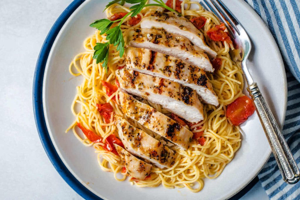 Italian grilled chicken sliced and served on a bed of pasta.