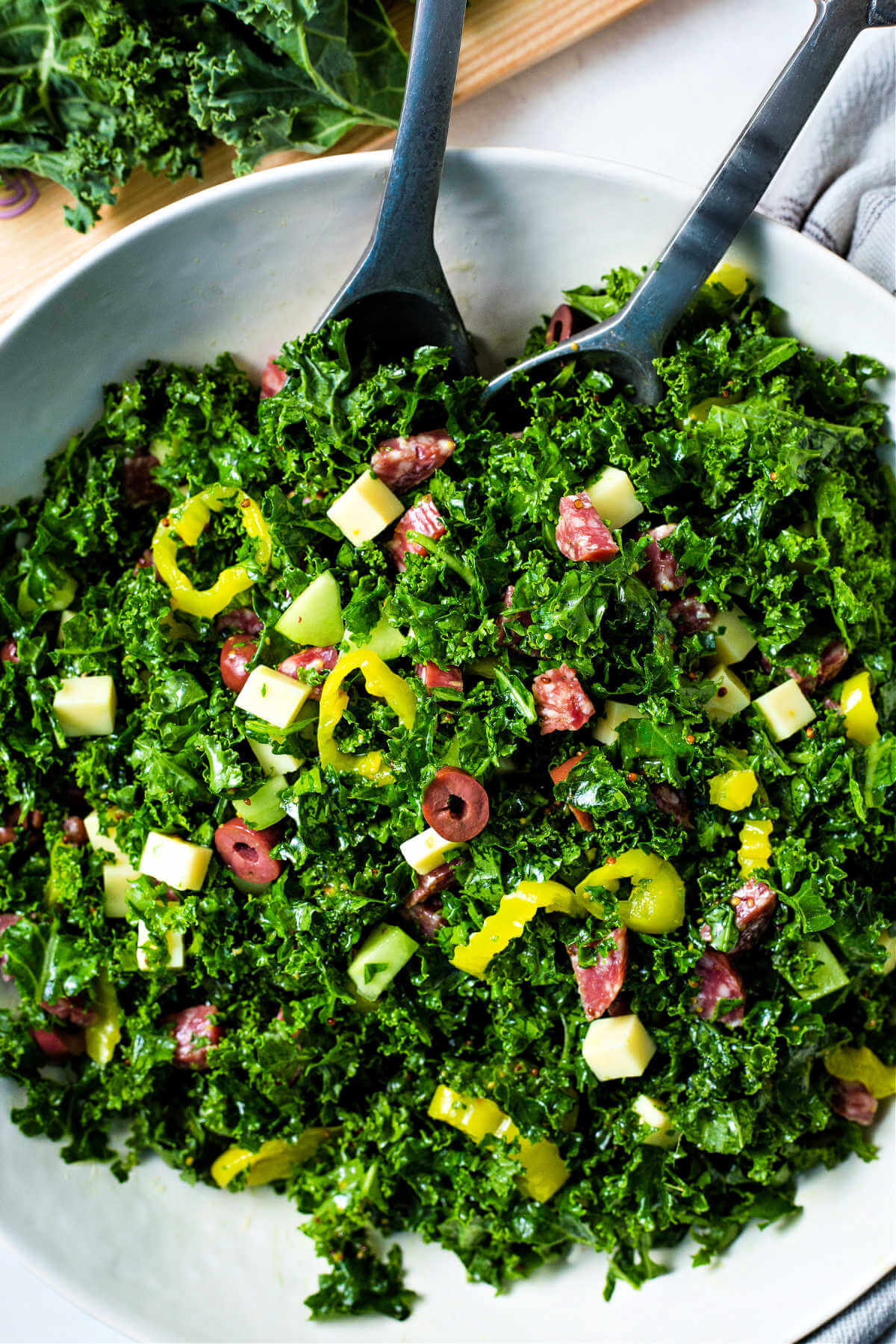 tossing the vinaigrette and other ingredients together for a chopped kale salad.