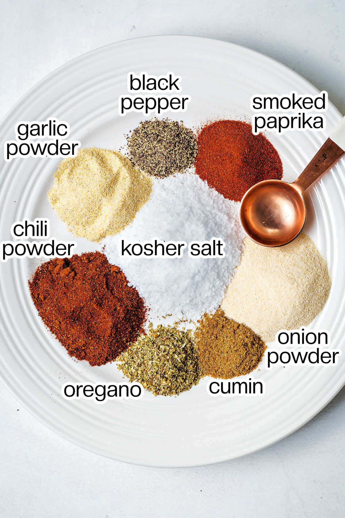 ingredients for homemade steak seasoning on a plate on a table.