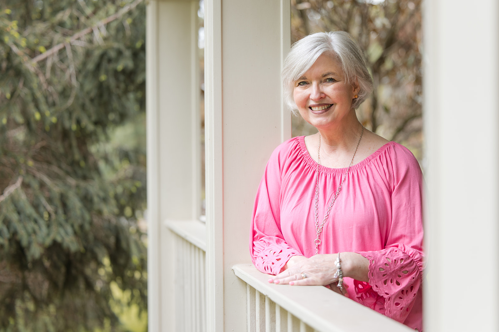 Sheila Thigpen leaning on a porch rail 