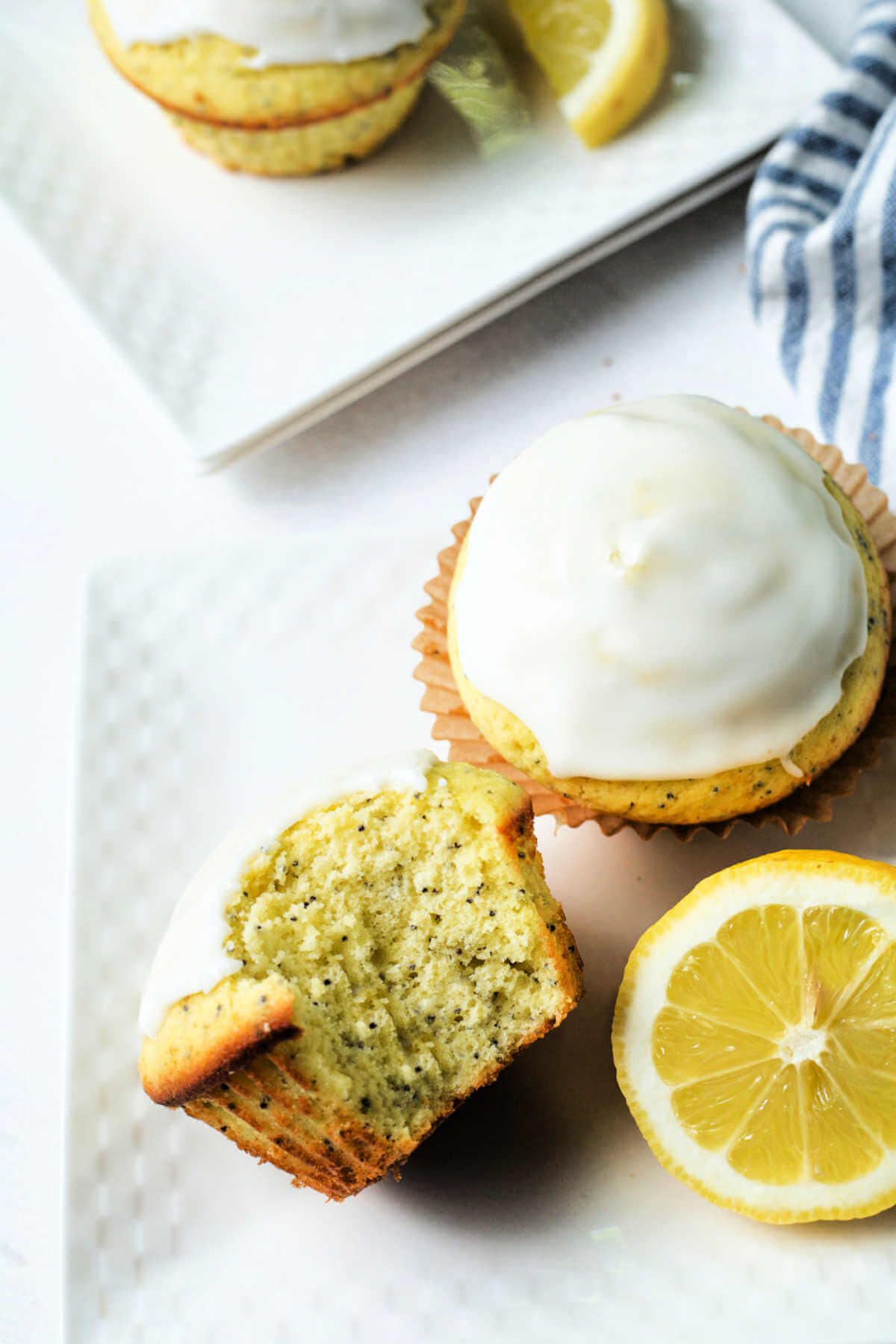 a lemon poppyseed muffin on a plate with a bite missing.