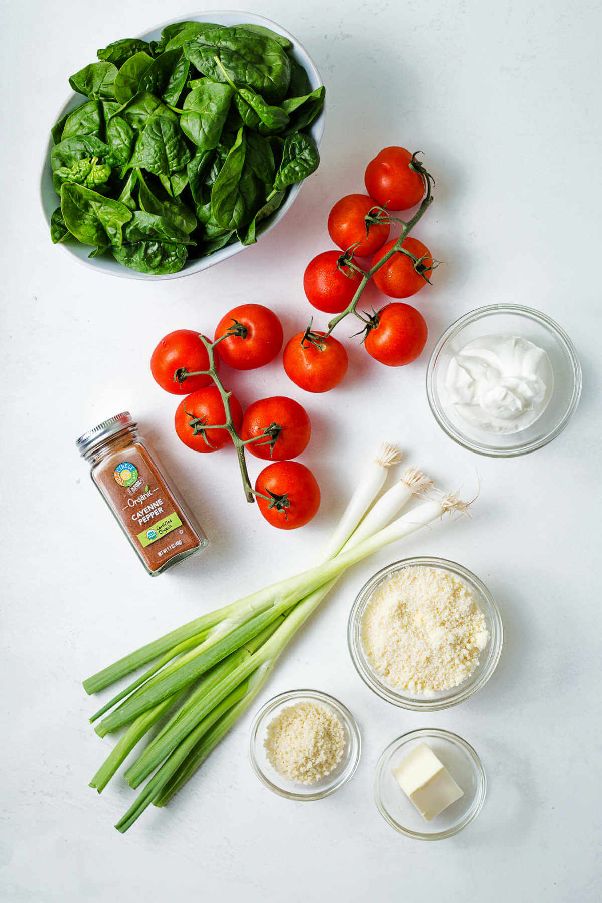 ingredients for spinach stuffed baked tomatoes on a table.