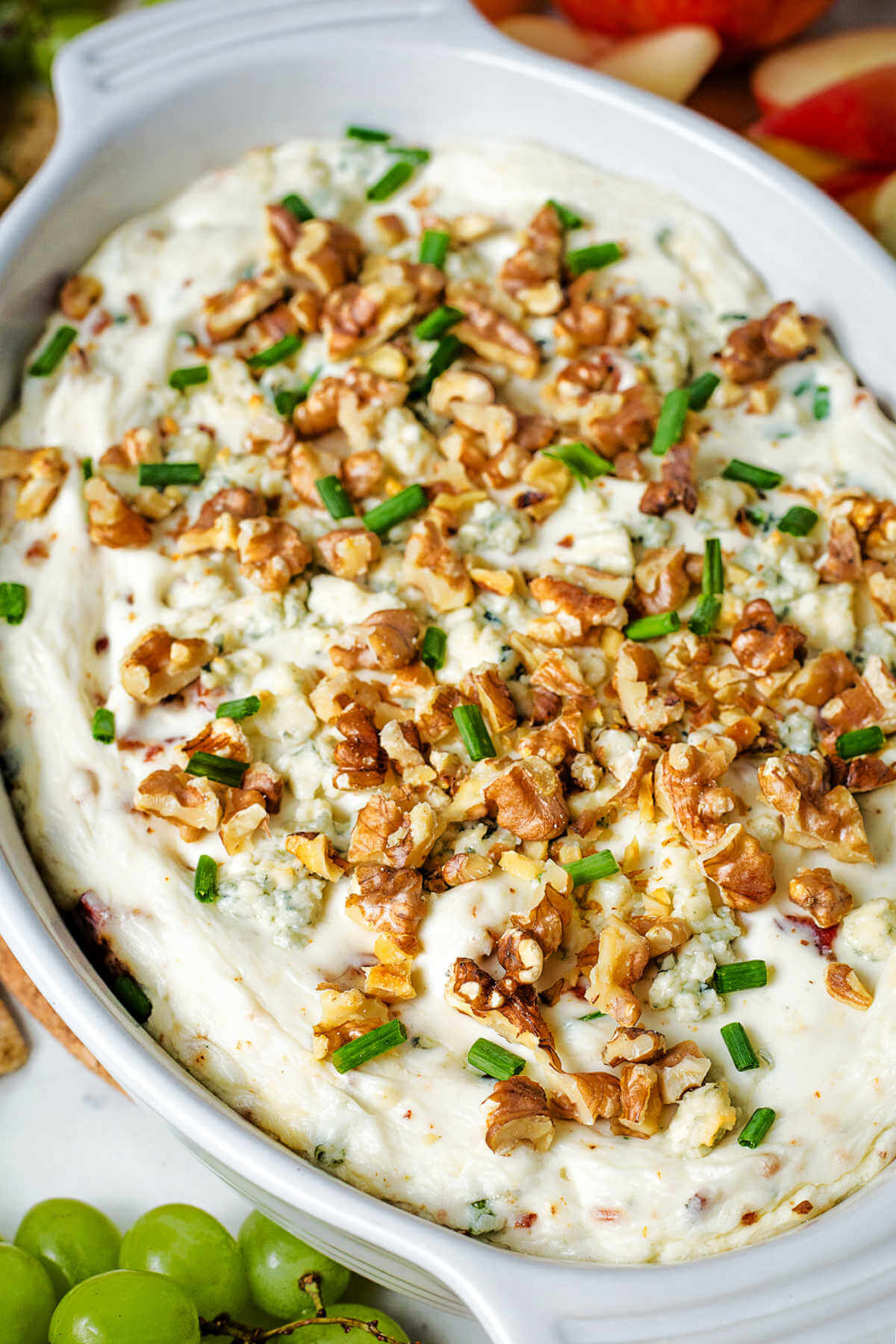 close up image of blue cheese dip topped with walnuts on a table.