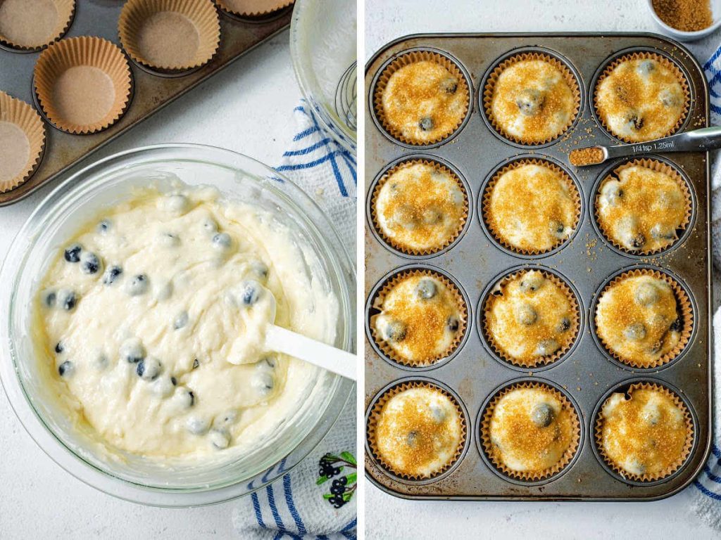 a muffin pan filled with batter for blueberry muffins with sugar sprinkled on top.