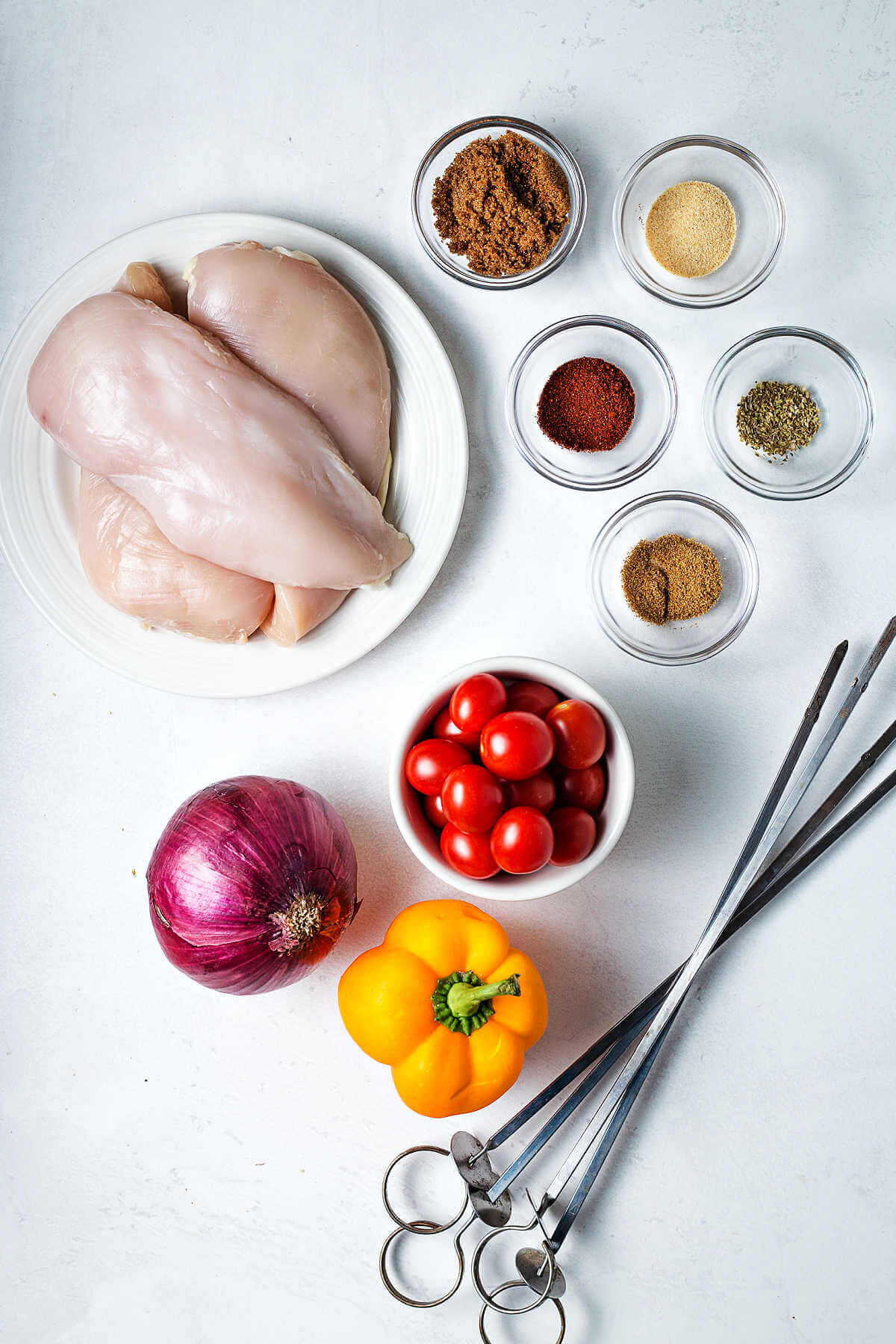 ingredients for grilled chicken kabobs on a table.