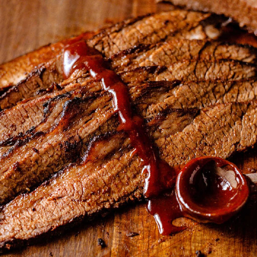 sllces of smoked brisket with BBQ sauce