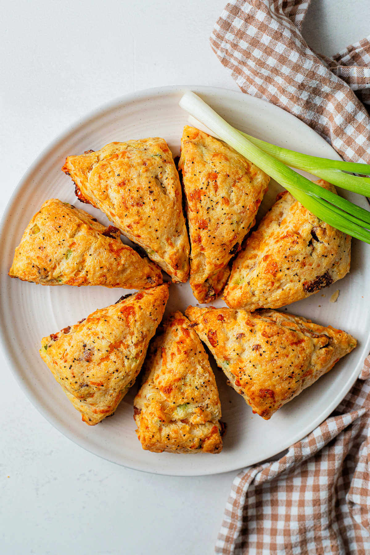 bacon cheddar scones on a white plate on a table.