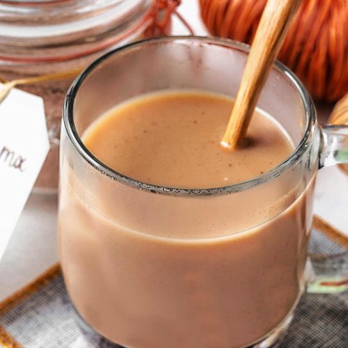 chai tea in a glass mug on a coaster.