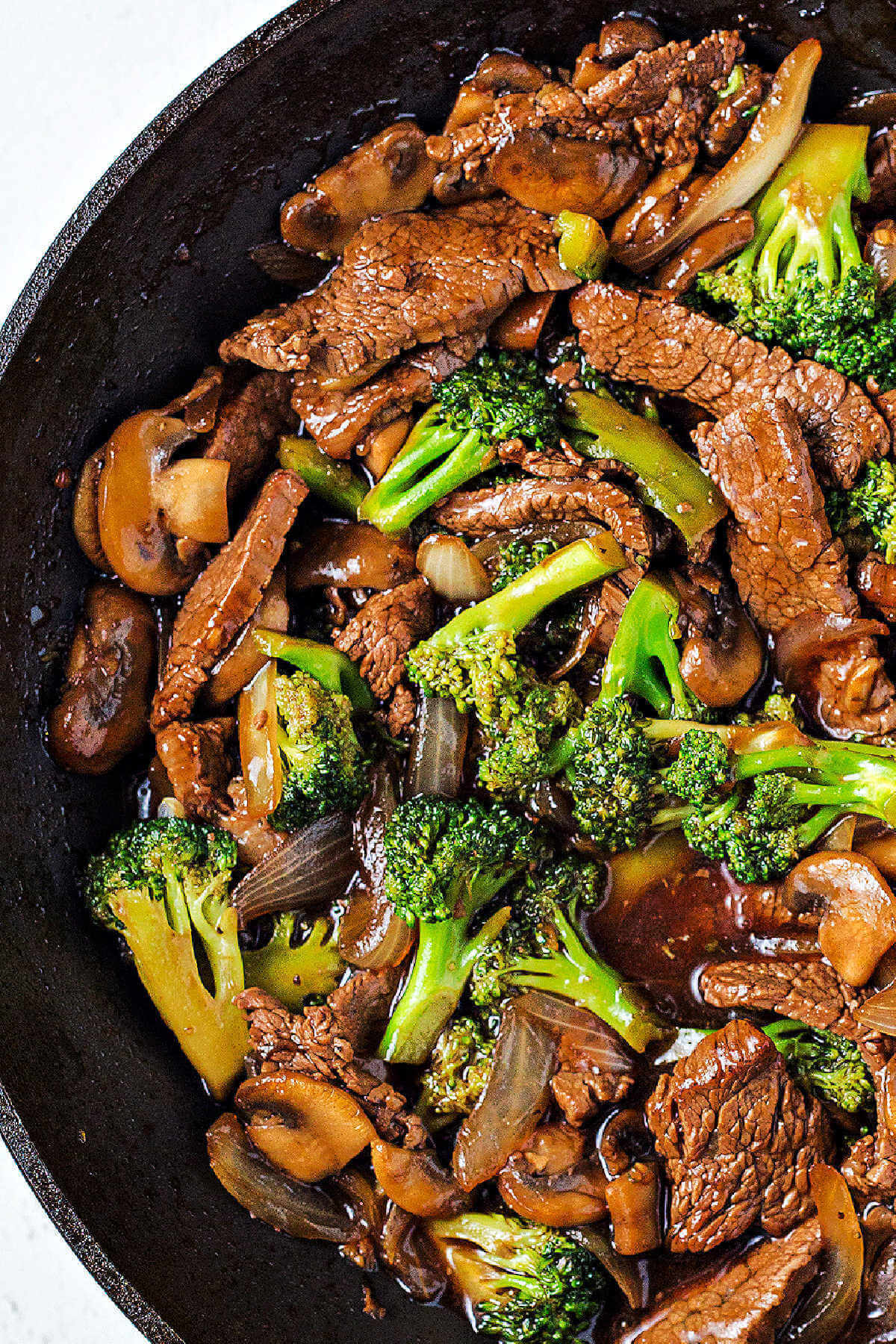 beef and broccoli cooking in a wok.