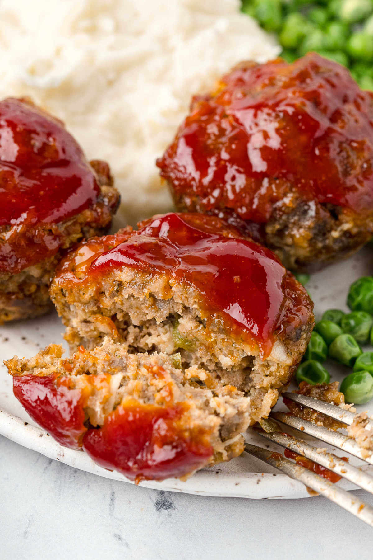 a meatloaf muffin cut in half on a plate.