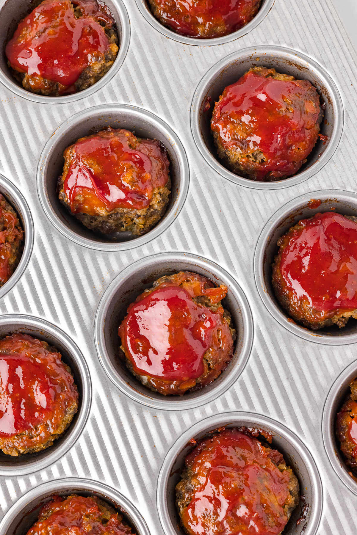 baked mini meatloaf muffins in a muffin pan.