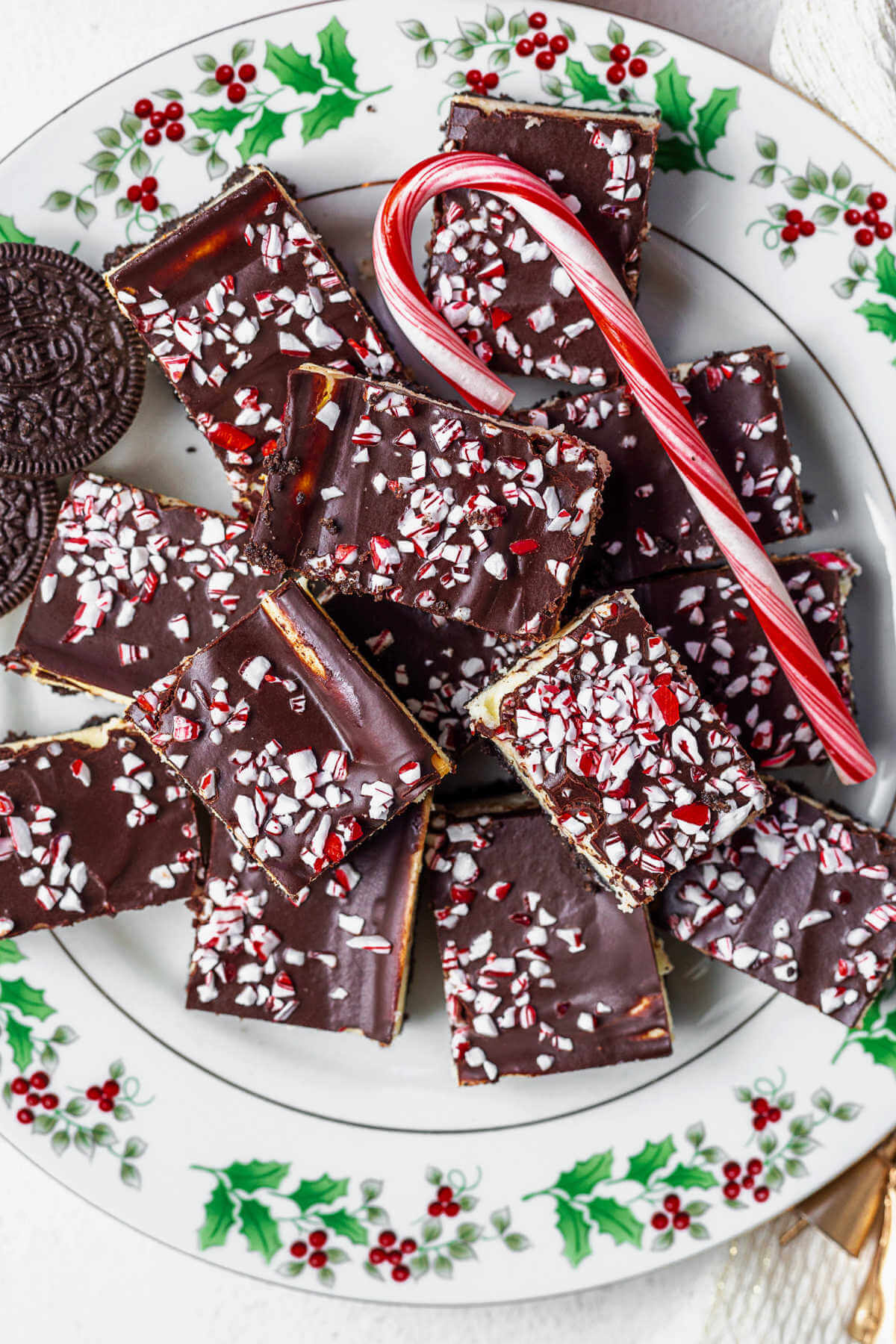 peppermint cheesecake bars on a plate with a candy cane.