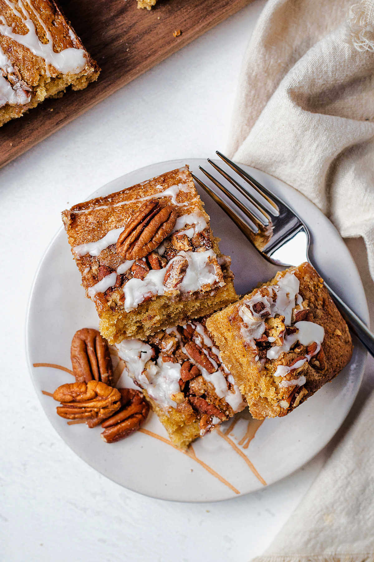 slices of coffee cake on a plate with a fork on a table.