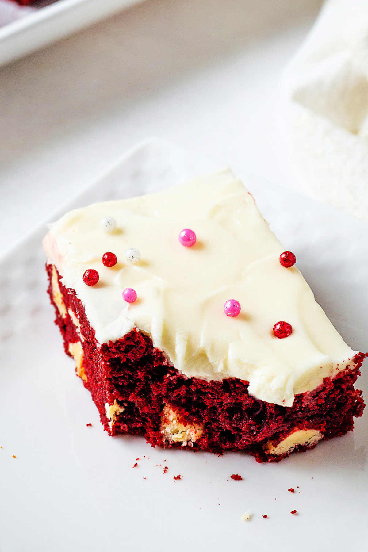 a red velvet brownie missing a bite on a plate.