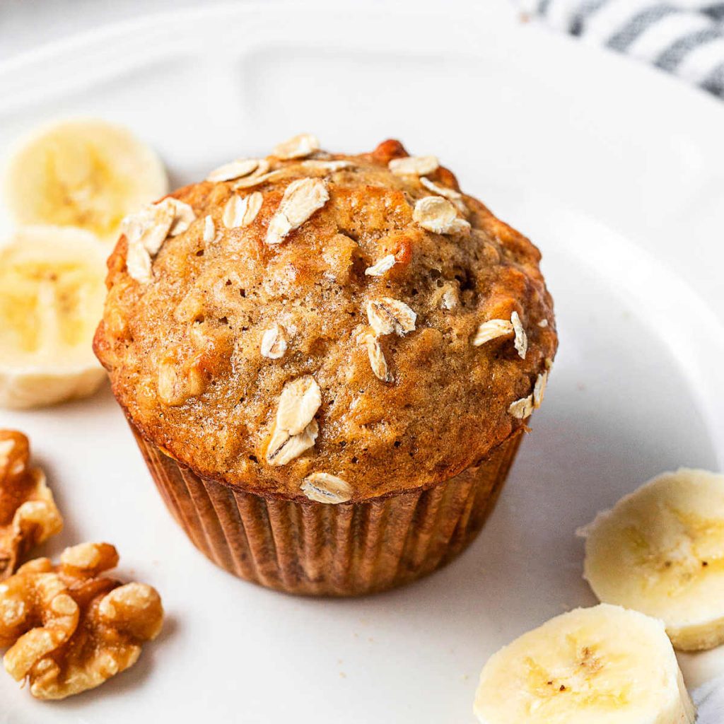 Banana Oat Muffin in a paper liner on a plate.