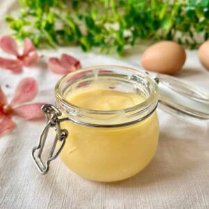 Lime Curd in a jar on a table.