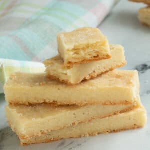Shortbread cookies stacked on a plate on a table.