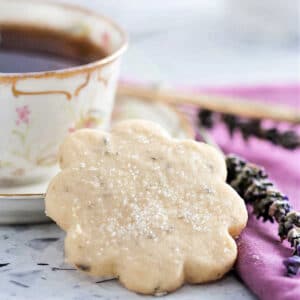A shortbread lavender cookie and a cup of tea on a table.
