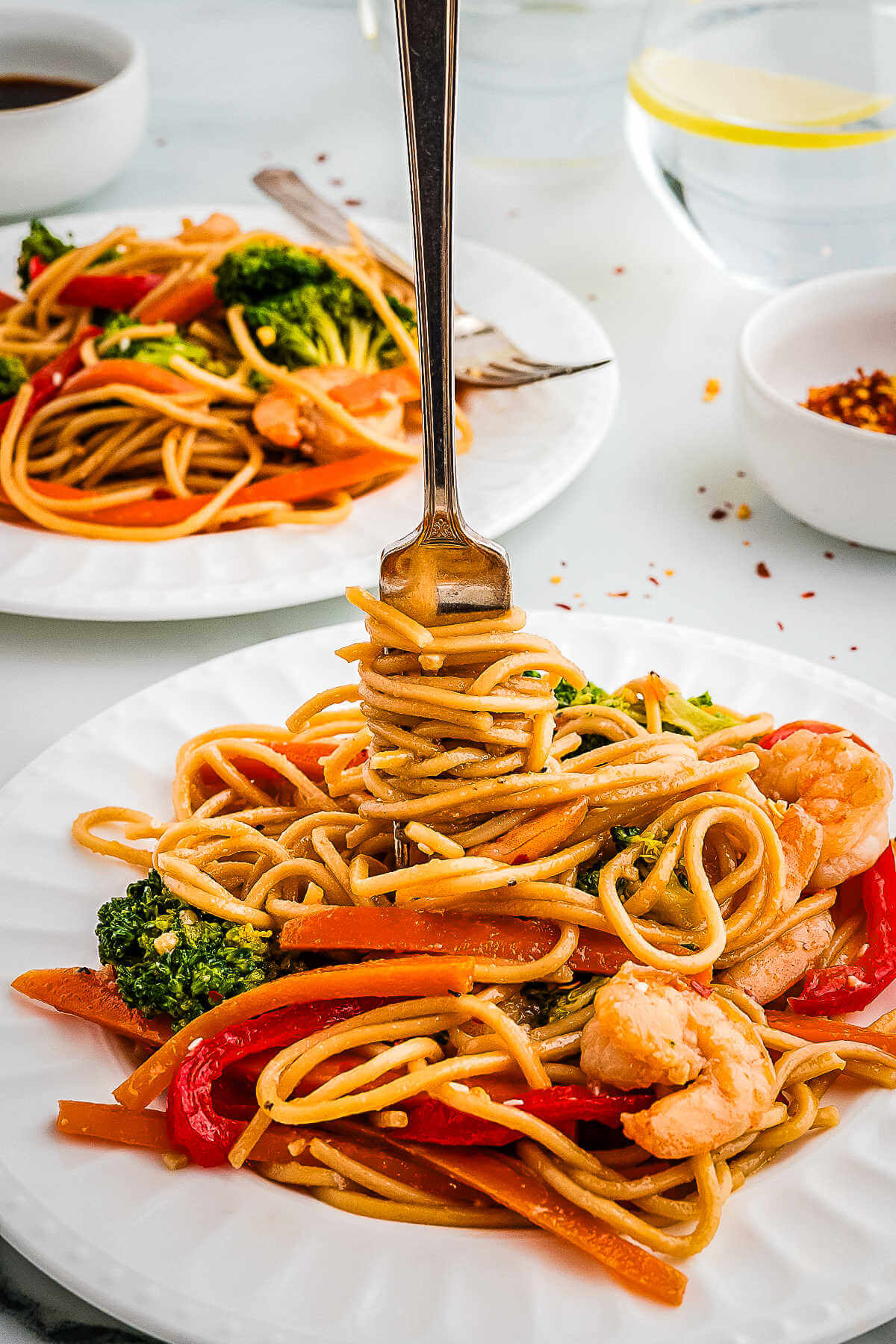 A fork twirling noodles on a plate.