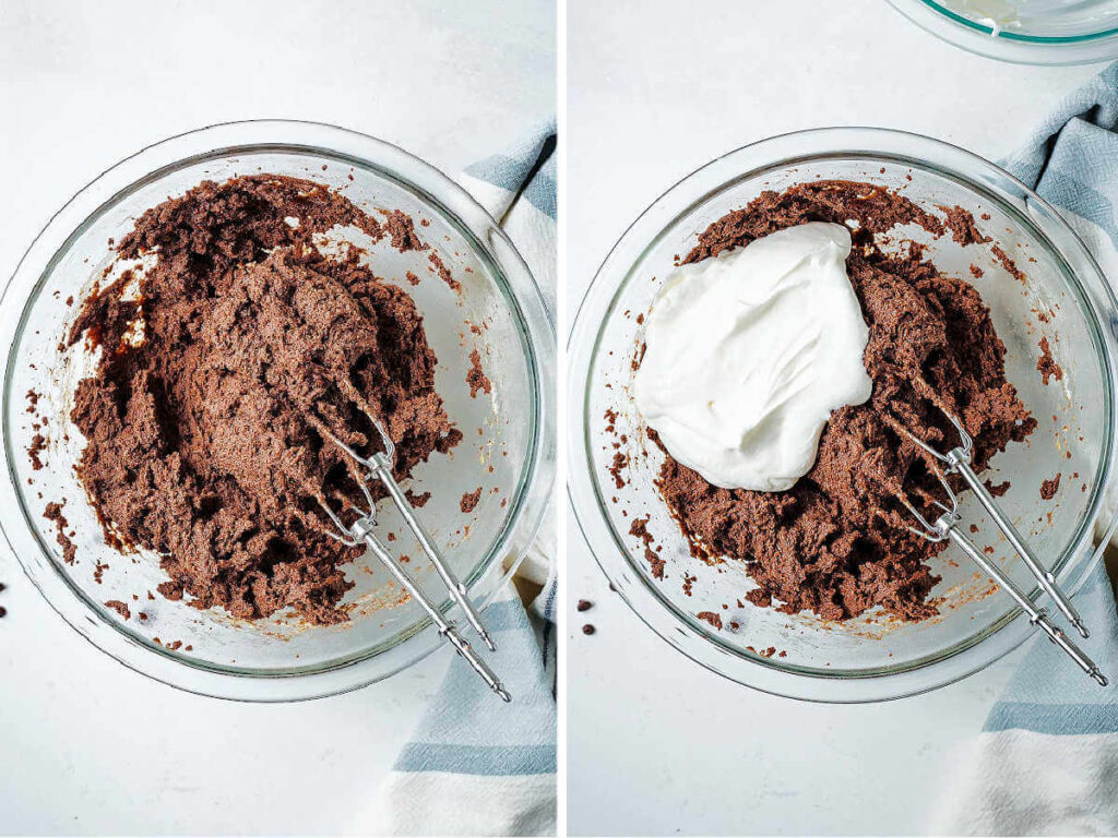 Brownie batter in a bowl with beaters from a handheld mixer; whipped cream added to the bowl to make brownie dip.