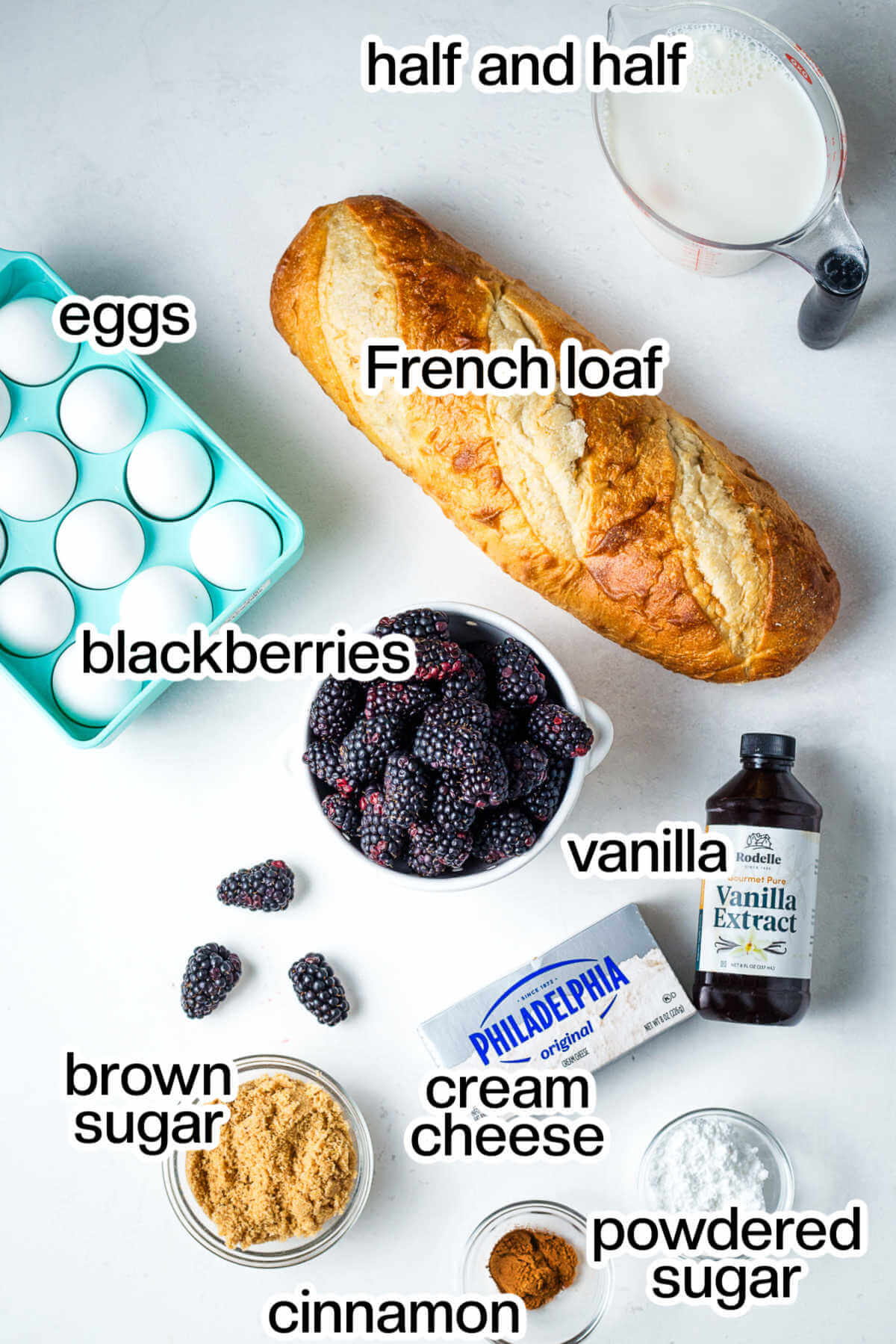 Ingredients for cream cheese french toast casserole with blackberries on a table.