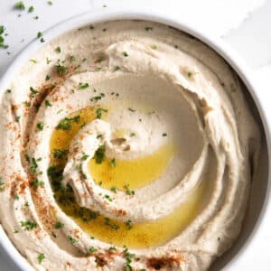 Hummus in a bowl drizzled with olive oil.