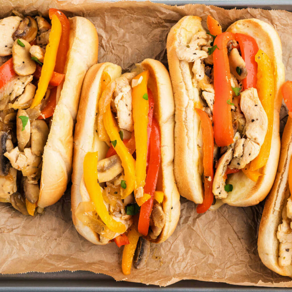Chicken Philly Sandwiches on a piece of parchment paper on a baking tray.