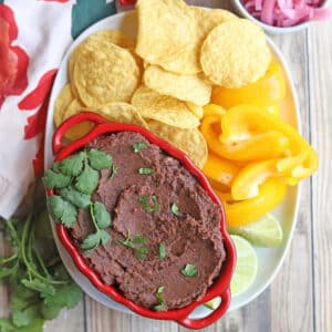 Chipotle Black Bean dip in a bowl with tortilla chips to the side.