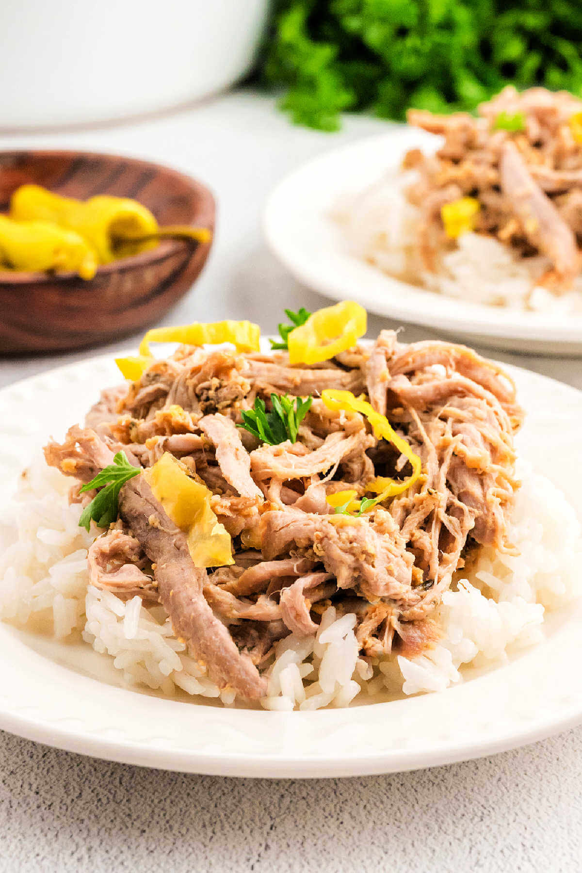 Shredded Mississippi Pork Roast on a bed of mashed potatoes on a table.