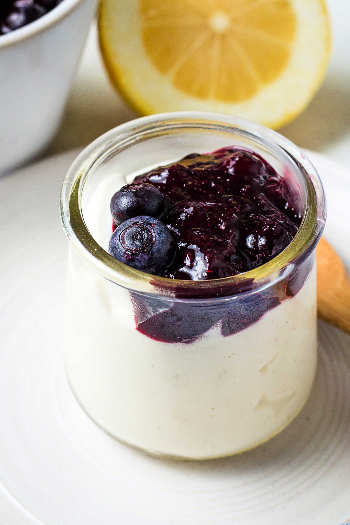 A bowl of Greek yogurt with blueberry compote ladeled on top.