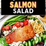 Grilled Salmon Salad on a plate with grilled asparagus, tomatoes, cucumbers, and feta cheese.