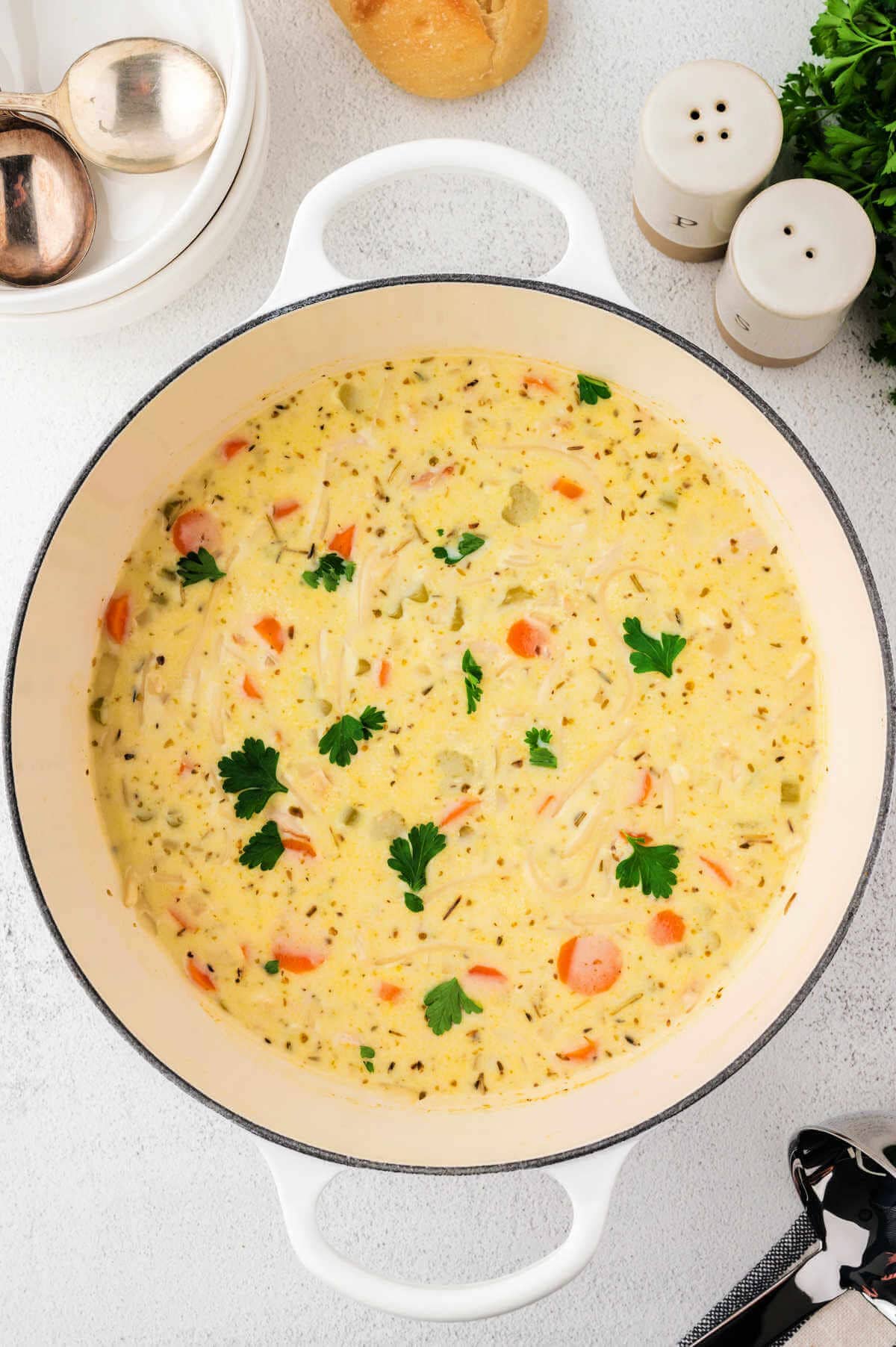 Creamy turkey noodle soup in a Dutch oven on a table.