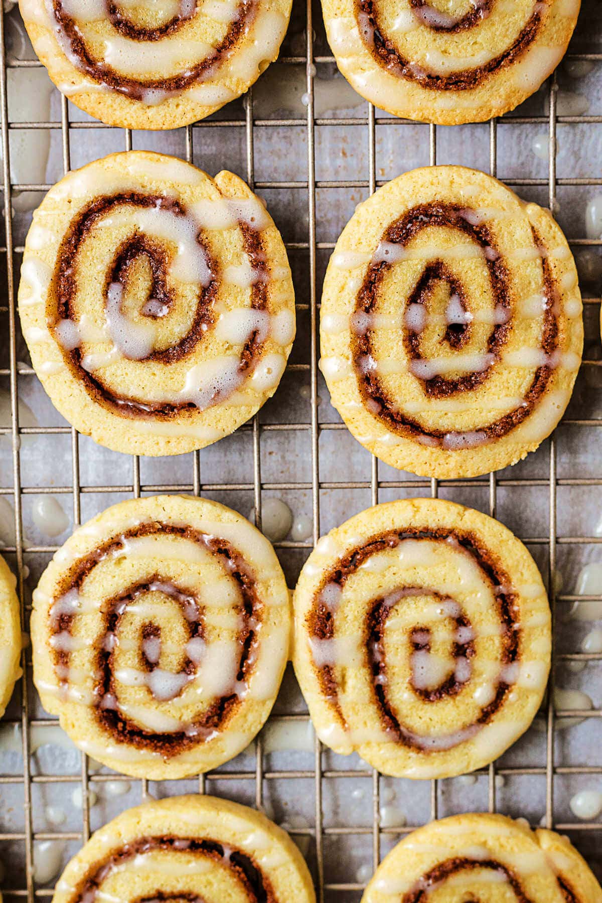 Cinnamon Roll Cookies on a wire rack with powdered sugar glaze.