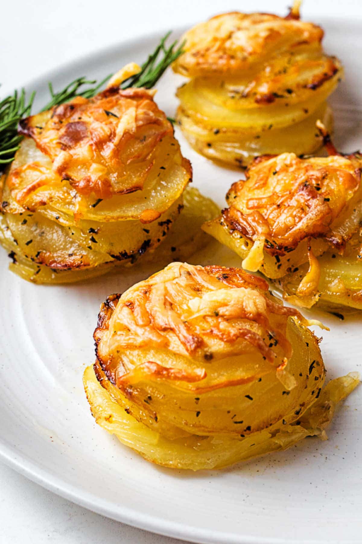 Close up image and side view of a crispy potato stack on a plate.