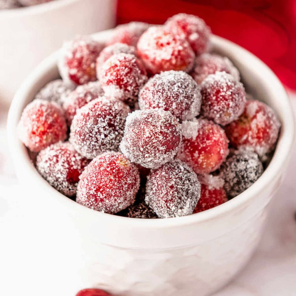 A bowl of candied cranberries on a table.