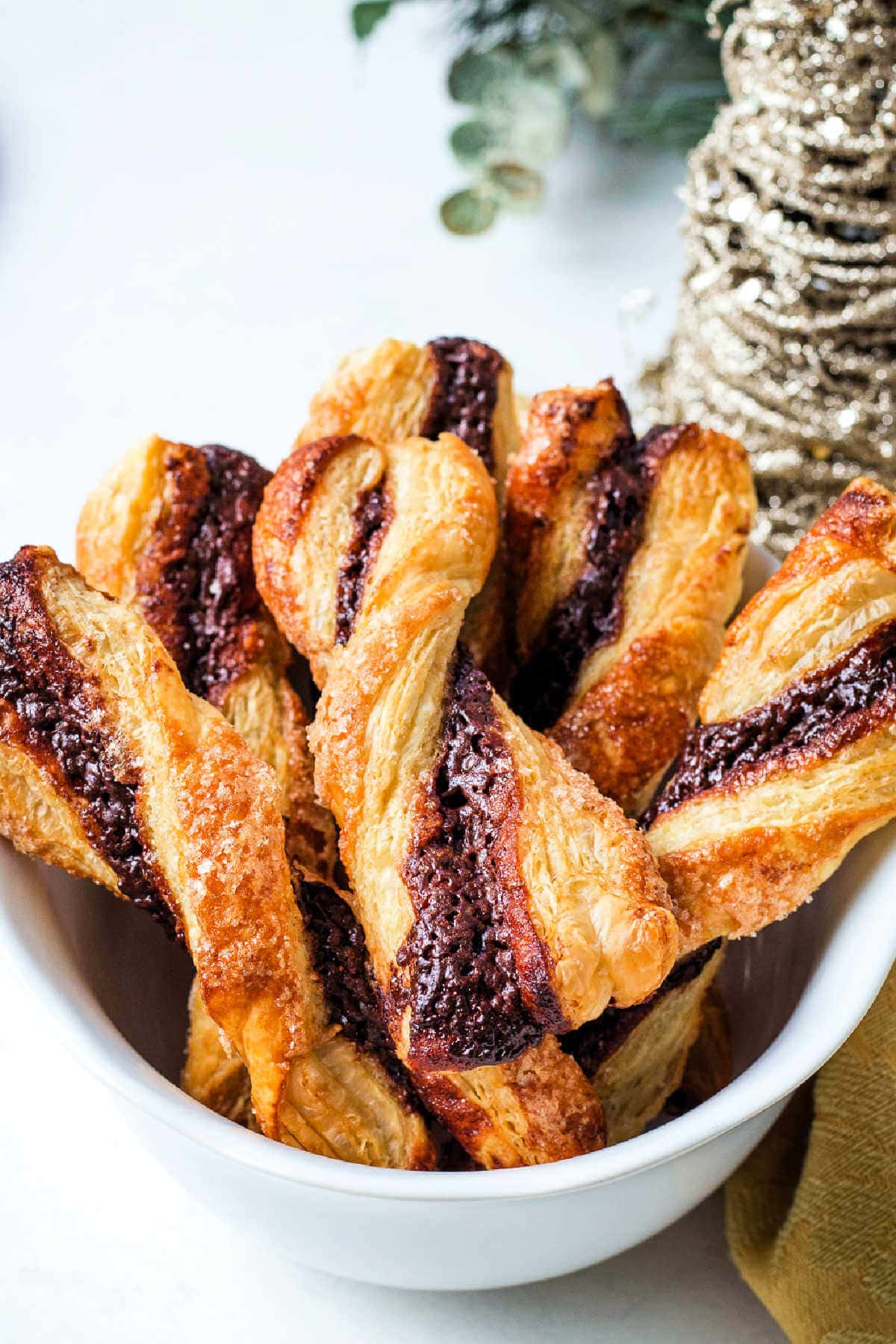 Chocolate Twists piled in a white bowl on a table.