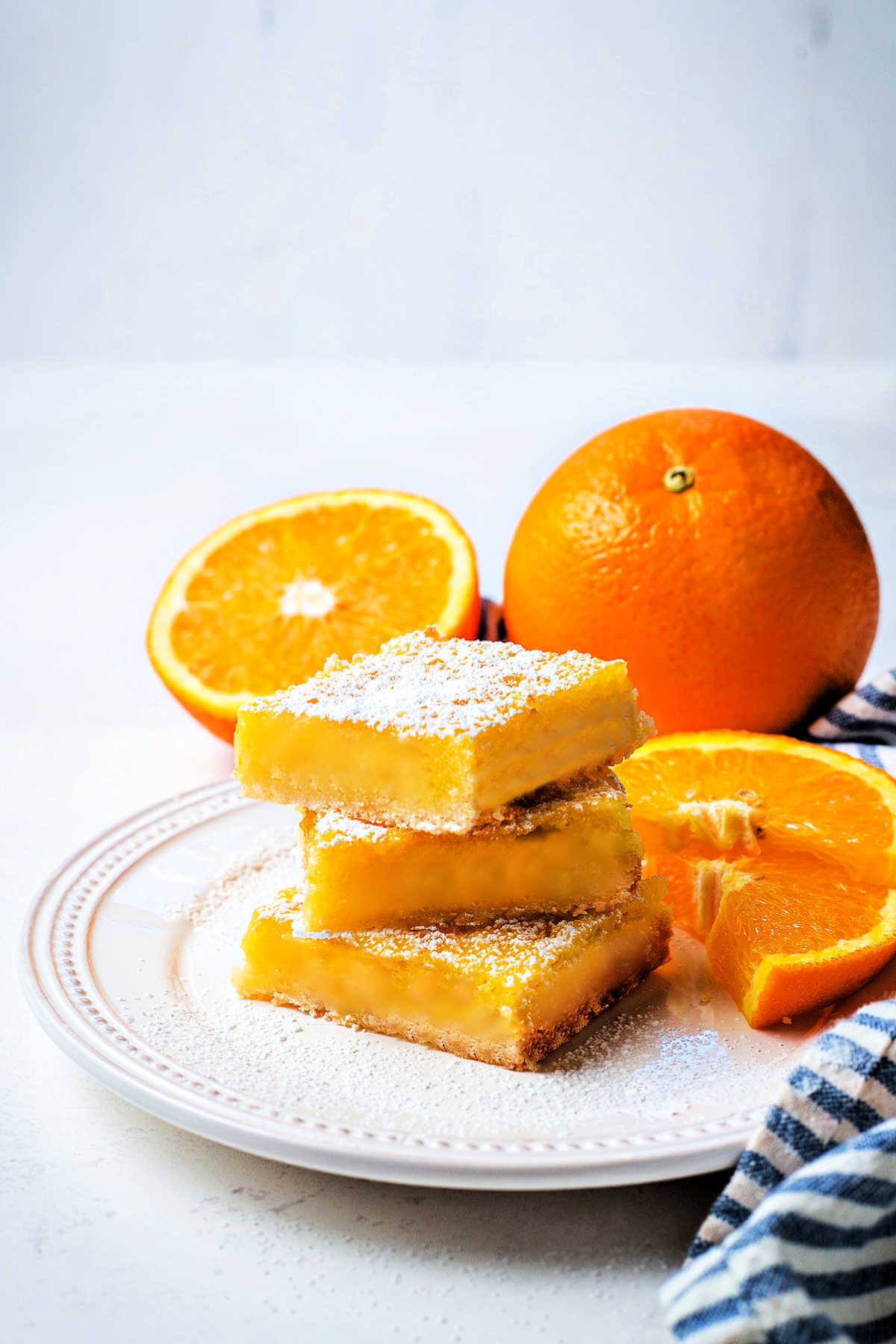 Orange bars on a plate with oranges in the background.