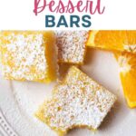 Orange bars stacked on top of each other on a plate with orange slices and powdered sugar dusted on top.