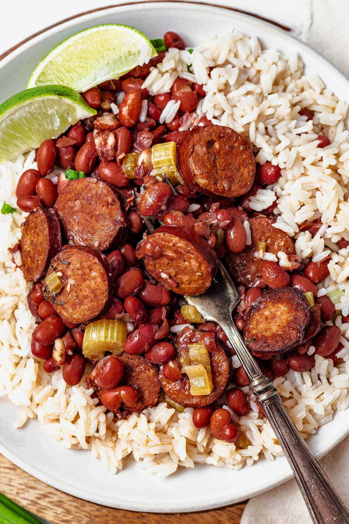 A fork in a serving of red beans, andouille sausage, and rice.