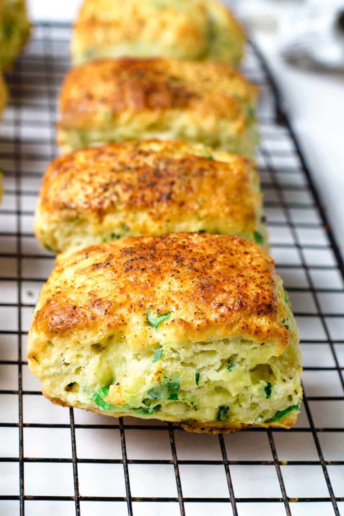 Savory scones cooling on a wire rack on a table.