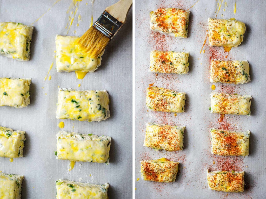 Brushing an egg wash onto unbaked scones on a baking sheet; tops of scones sprinkled with paprika before baking.