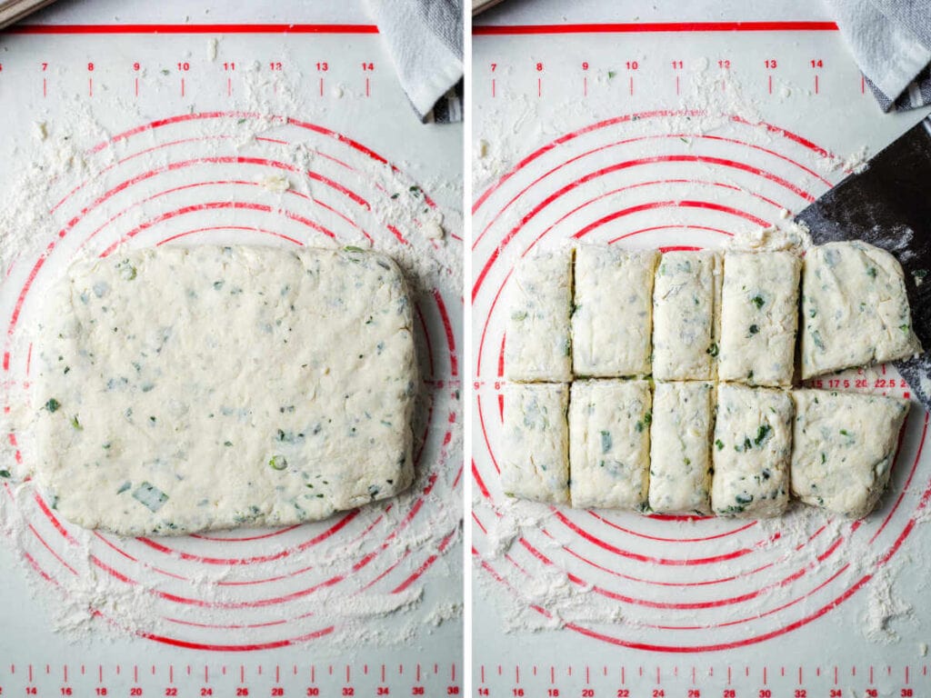 Dough for scones patted into a rectangle on a floured surface, then cut into pieces with a bench scraper.