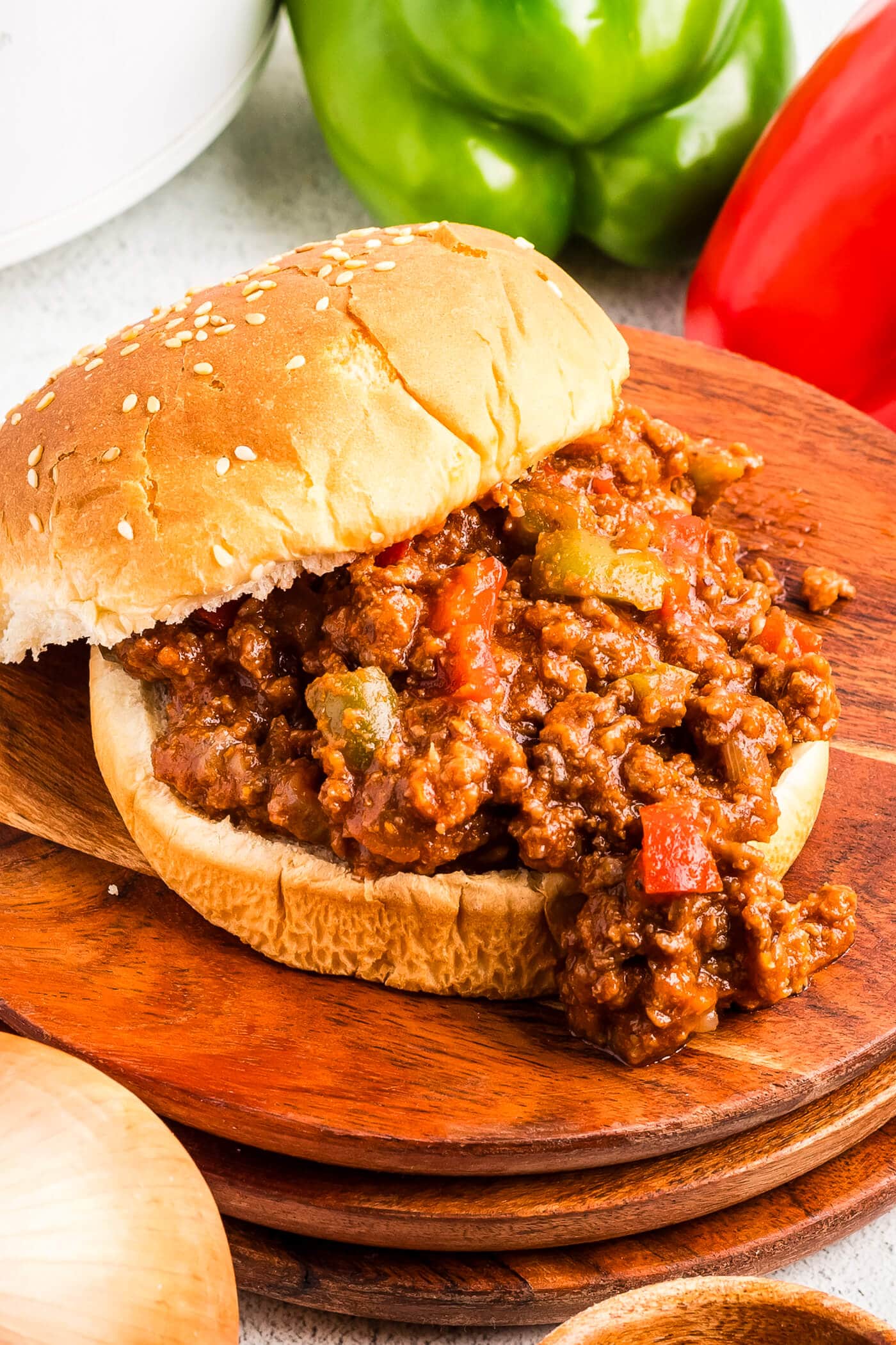 A Sloppy Joe Sandwich on a wooden board on a table.