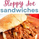 Sloppy Joe Sandwiches on a sesame seed bun on a wooded board.