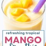 Mango Smoothie in a glass with mango pieces floating on top.