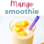 Mango Smoothie in a glass with mango pieces floating on top.