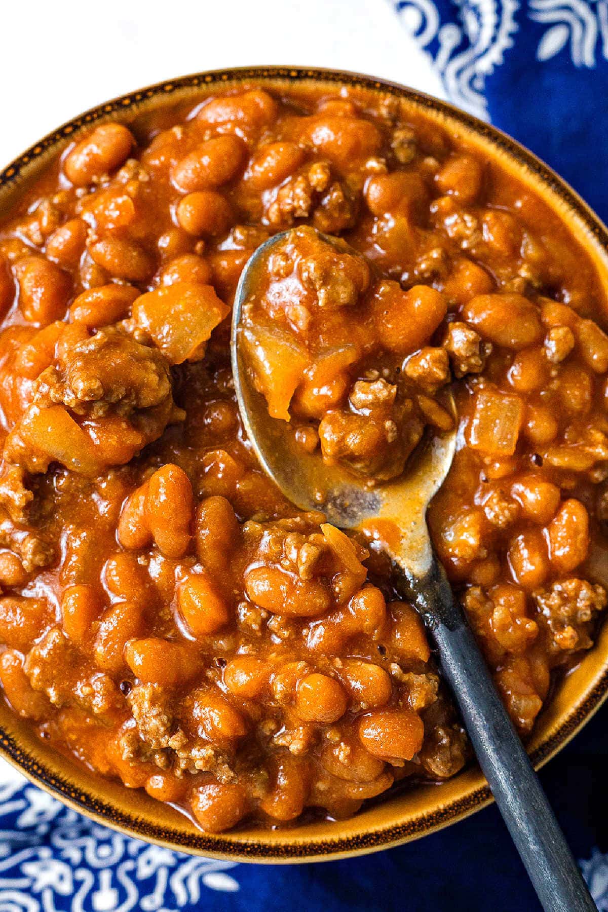 Slow cooker cowboy beans in a bowl with a spoon.