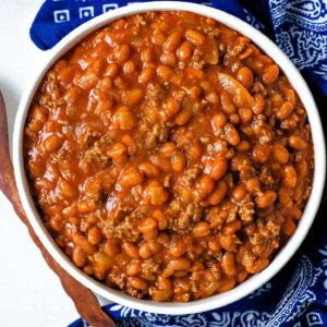 Cowboy Beans in a serving bowl on a table.